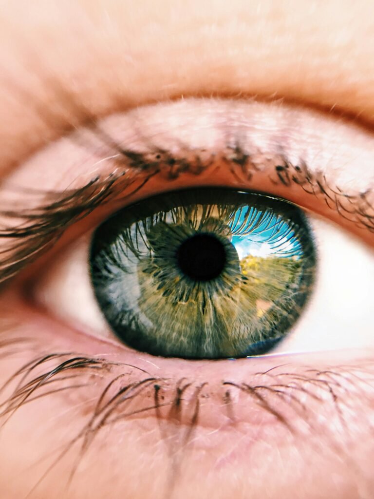 Detailed close-up photo of a human eye showing green iris and reflection.