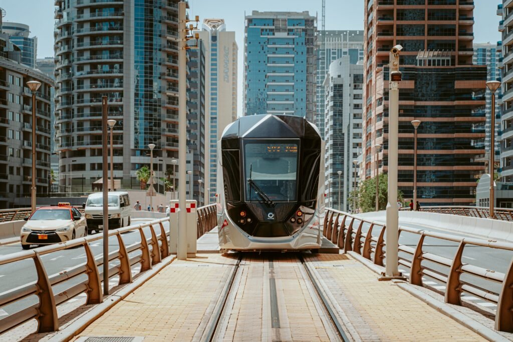 A sleek modern tram navigating through Dubai's urban architecture, showcasing innovative public transport.
