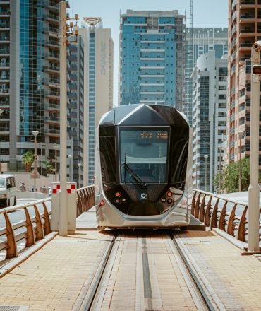 A sleek modern tram navigating through Dubai's urban architecture, showcasing innovative public transport.